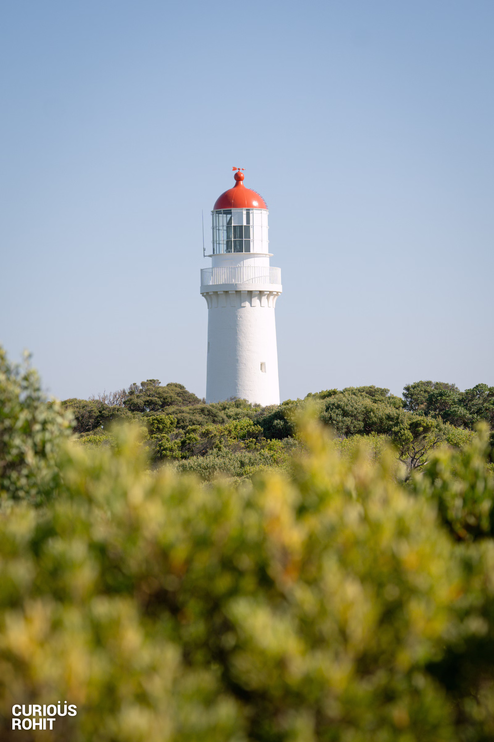A white lighthouse with a red top