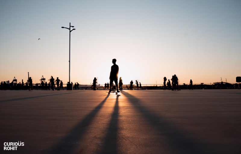 A man skateboarding on a sunset beach with a pier in the background