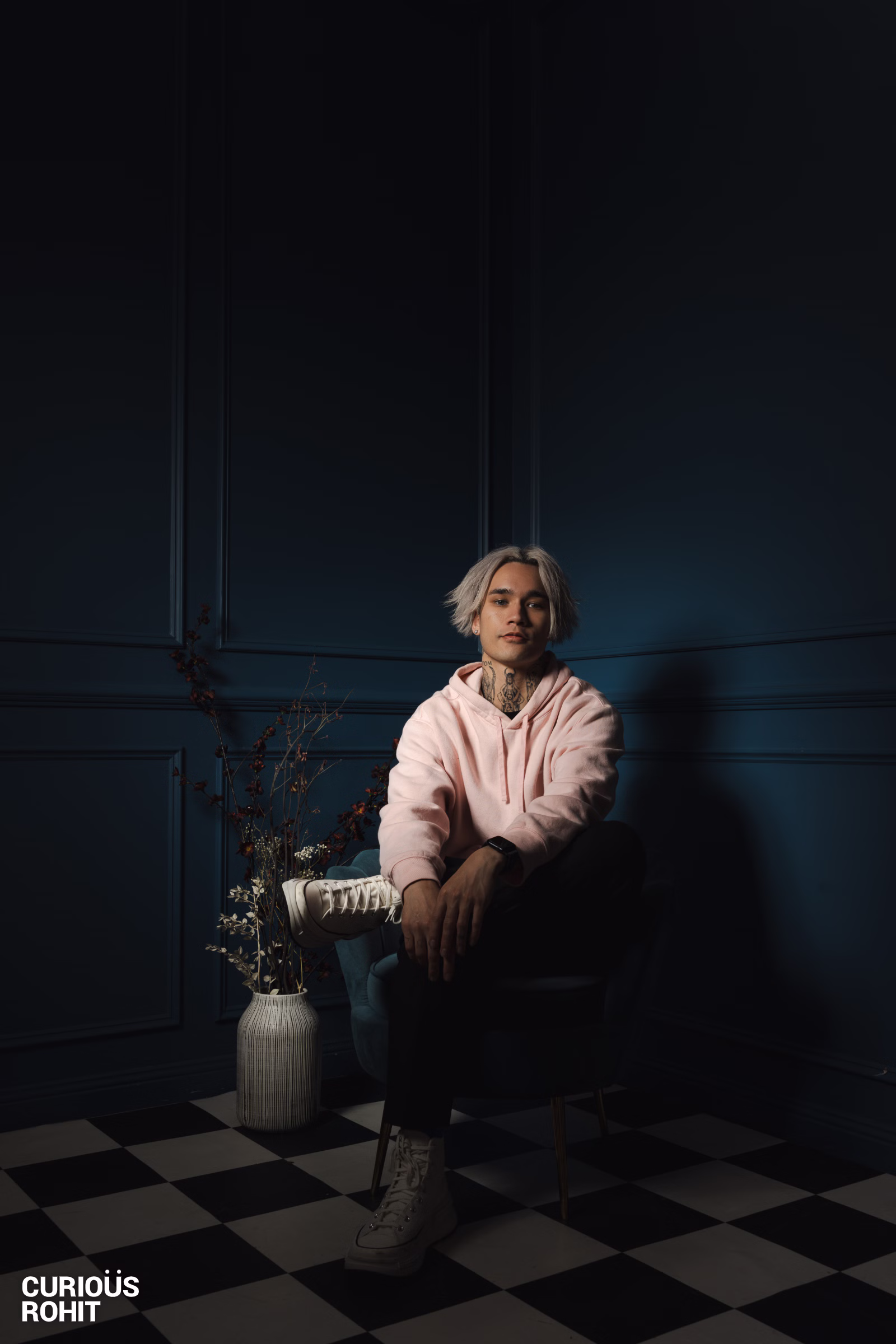 A man with spiky hair sitting in a chair