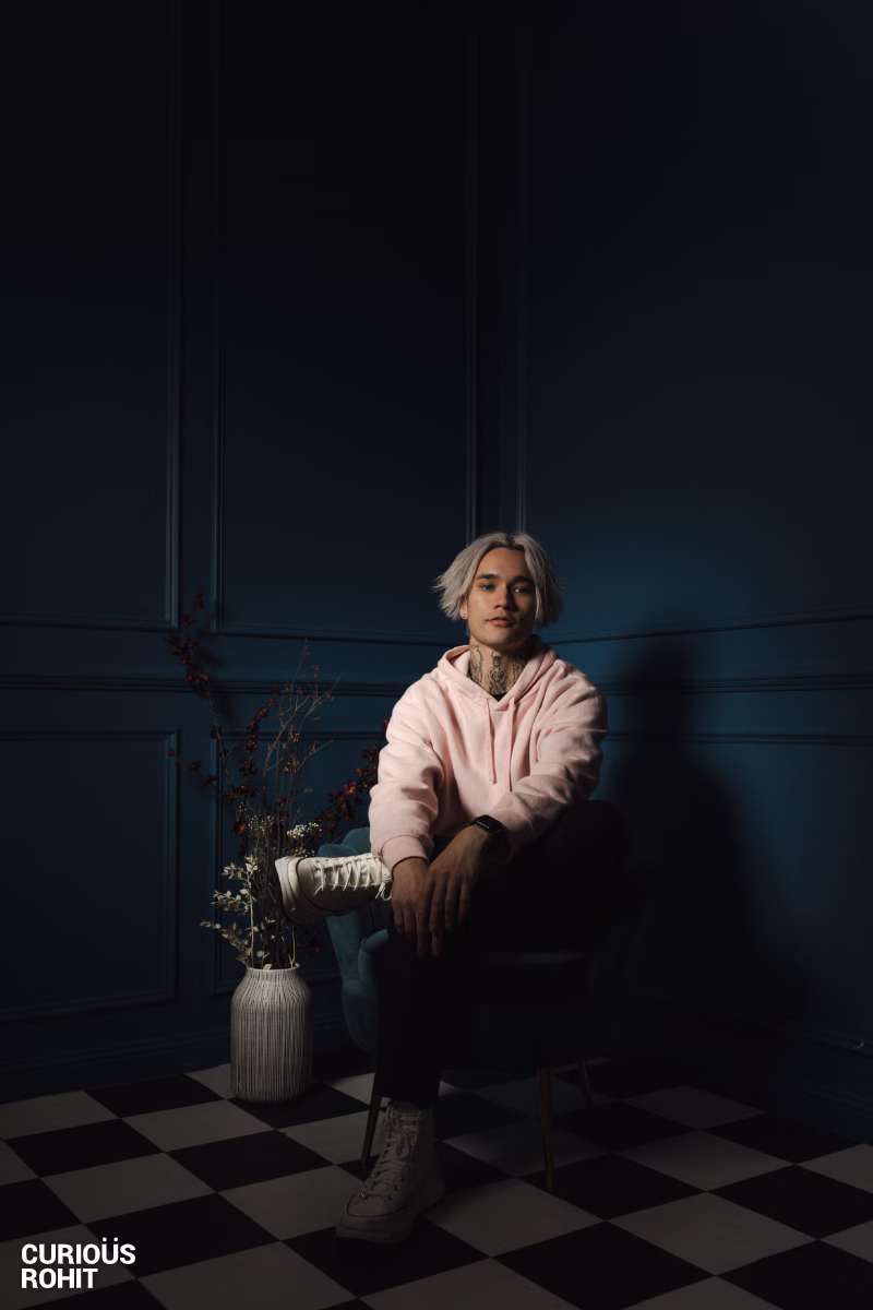 A man with spiky hair sitting in a chair