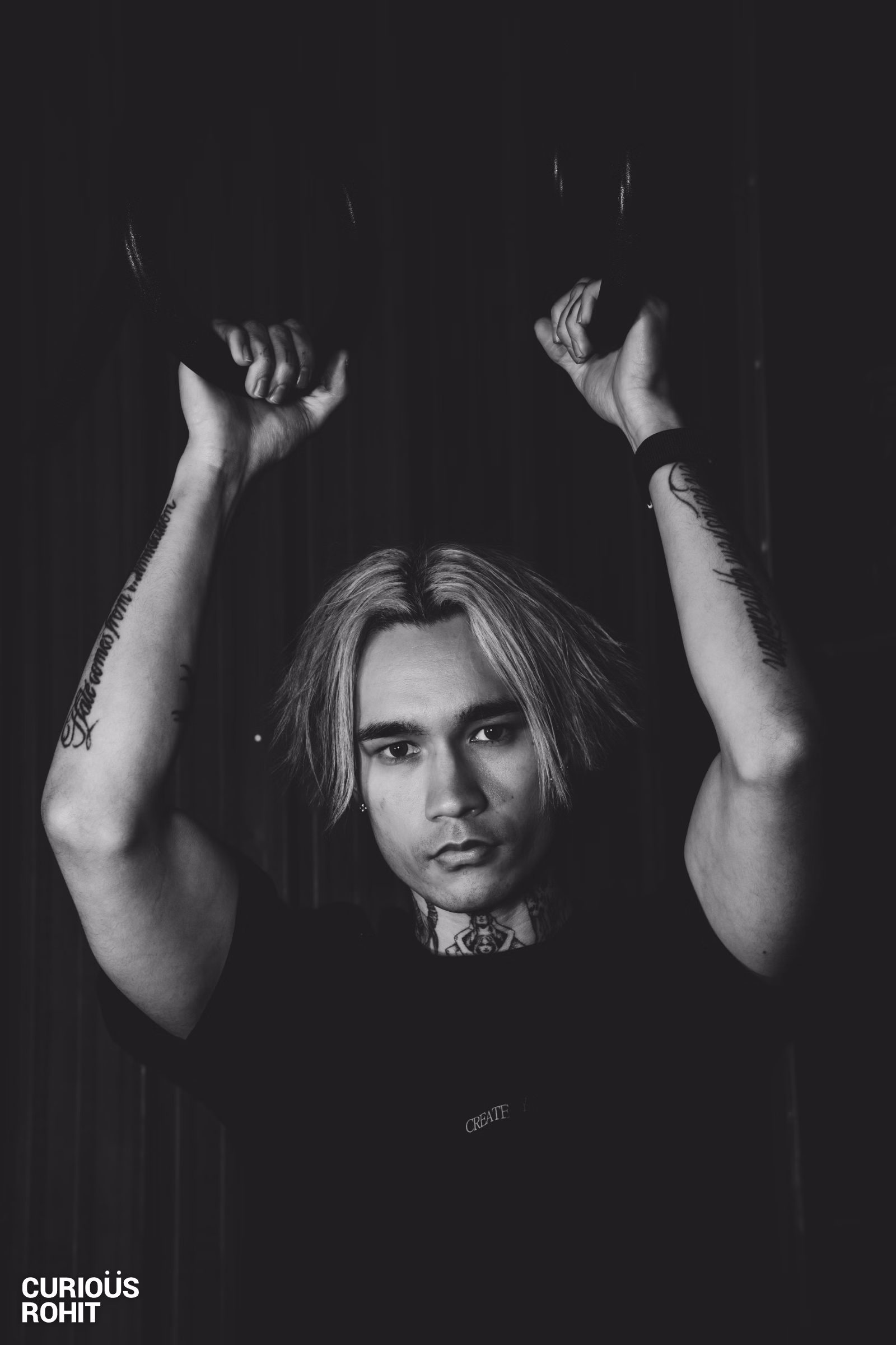 A man with tattoos and long hair posing for a picture