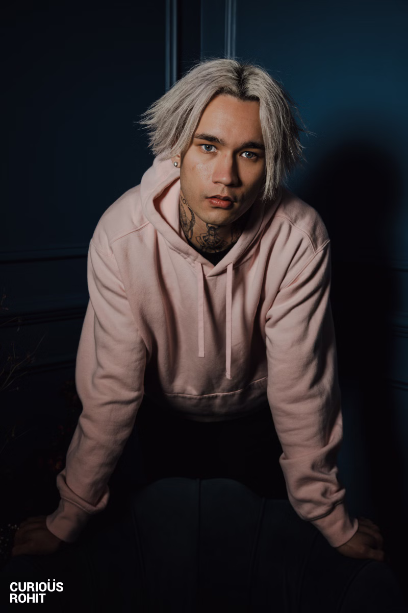 A man with blond hair wearing a pink hoodie