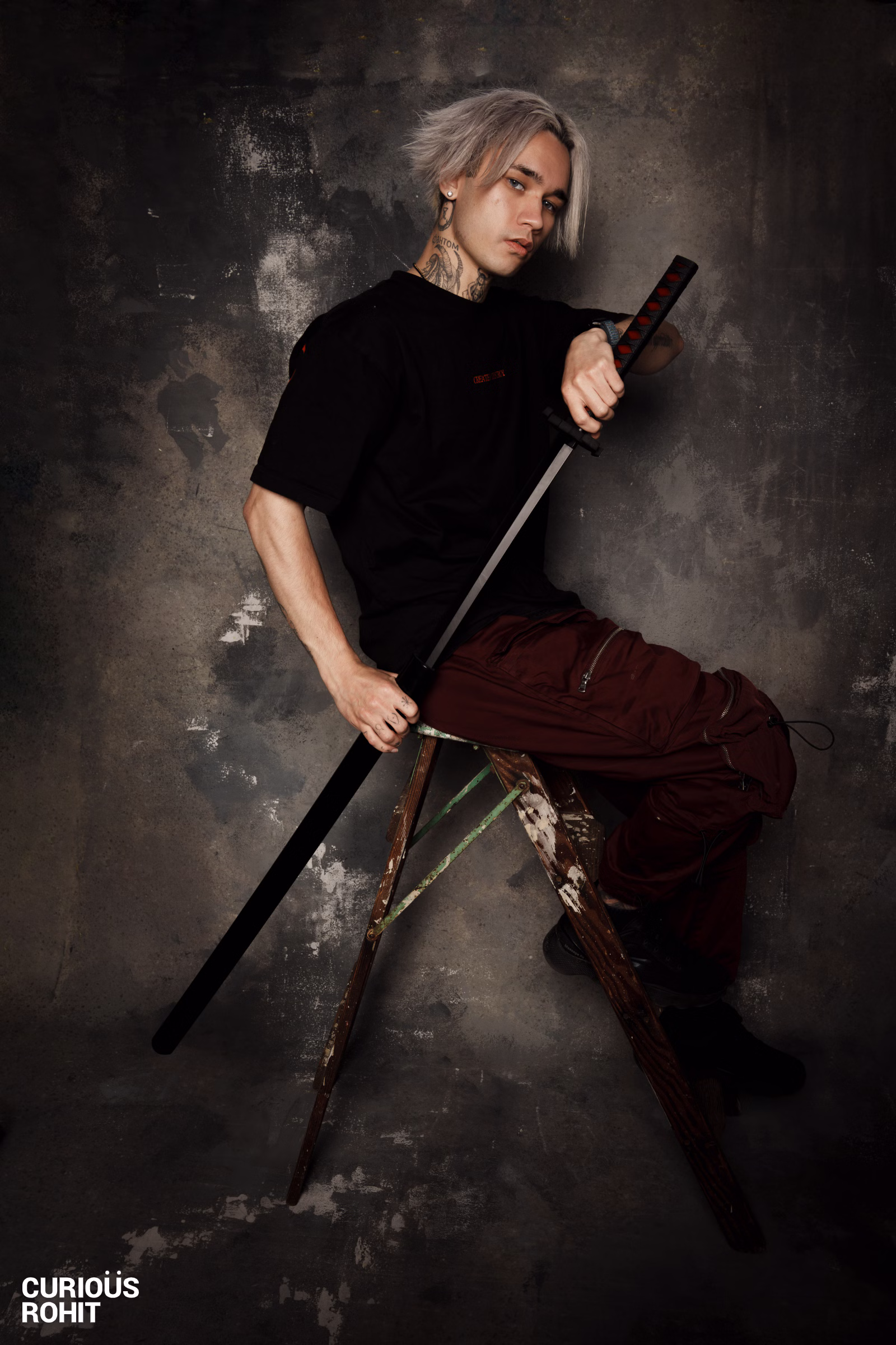 A man holding a sword in front of a wall